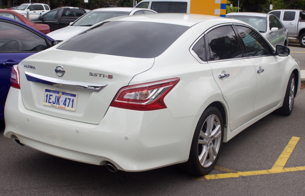 Rear design and taillight of a white sedan with chrome details.