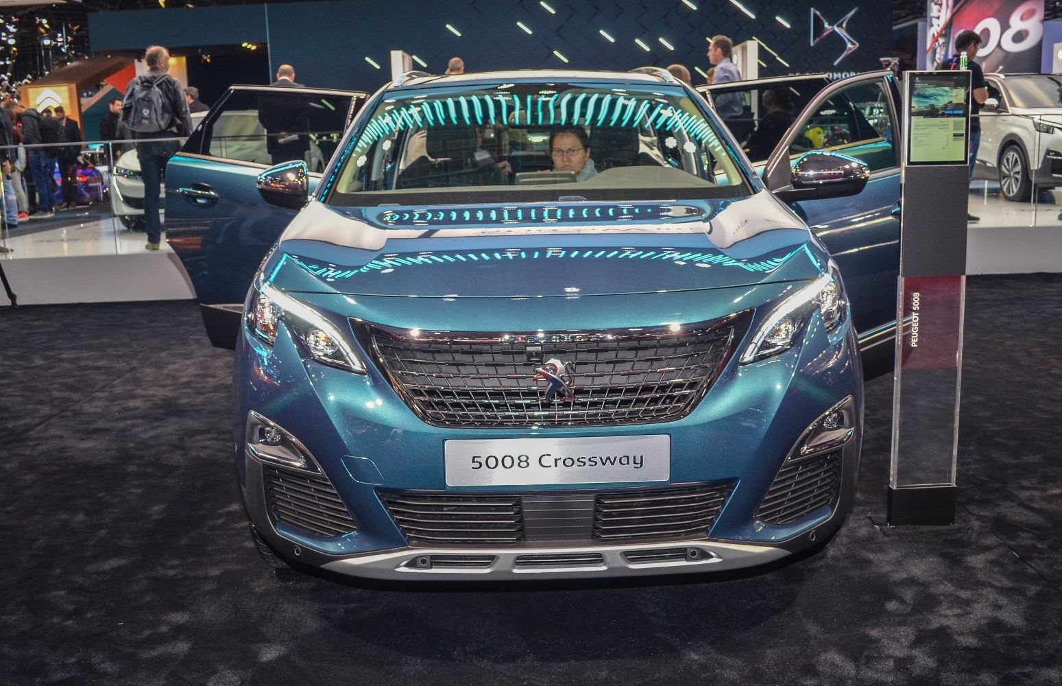 Front grille and LED headlights of a modern SUV with open doors
