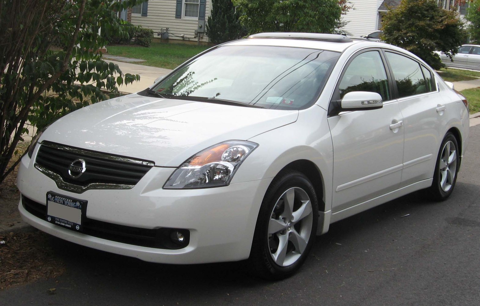 White four-door sedan with chrome grille and alloy wheels