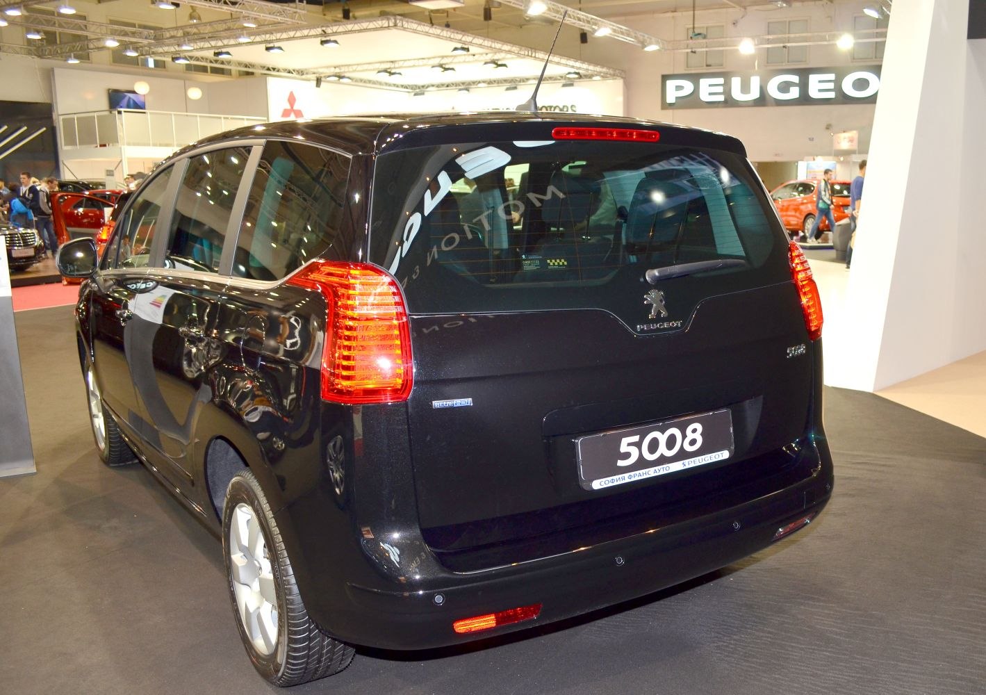 Rear view of black Peugeot with taillights and badge