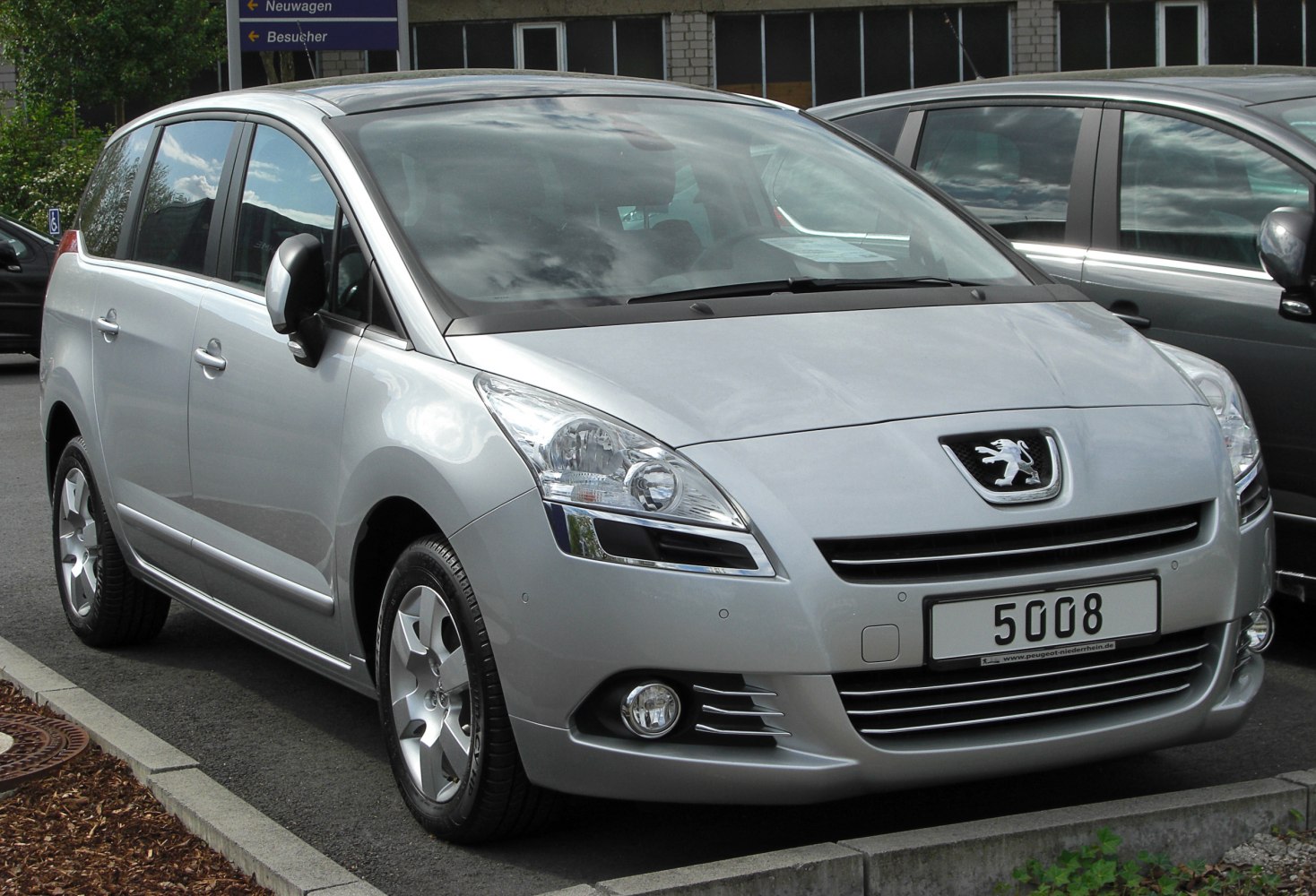 Front and side view of silver MPV with alloy wheels and clear headlights