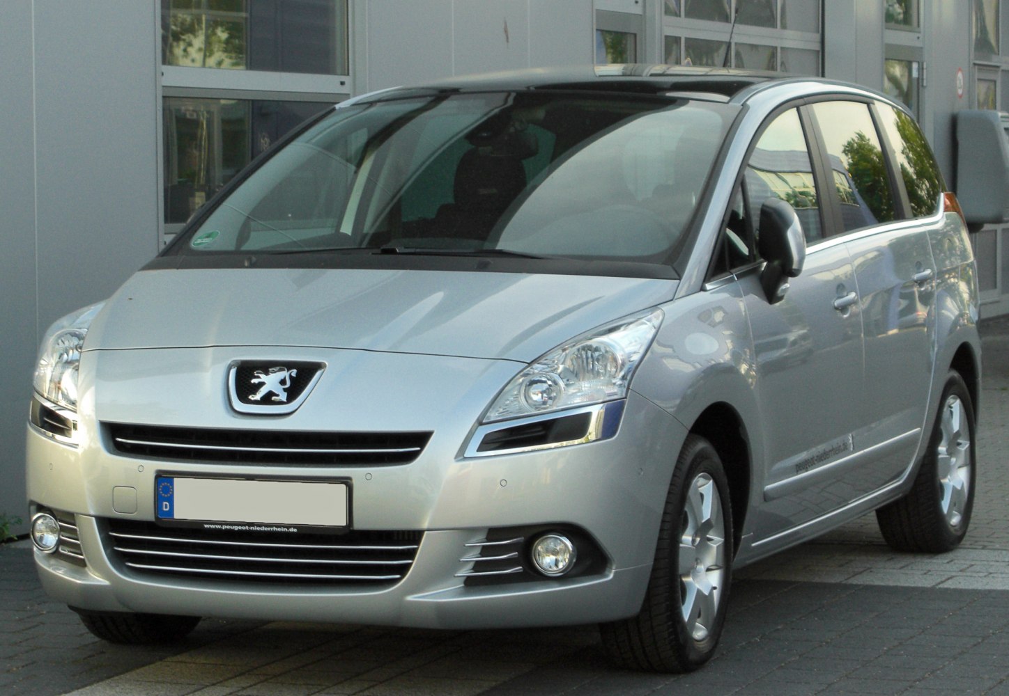 Silver MPV front with angular headlights and multi-slat grille