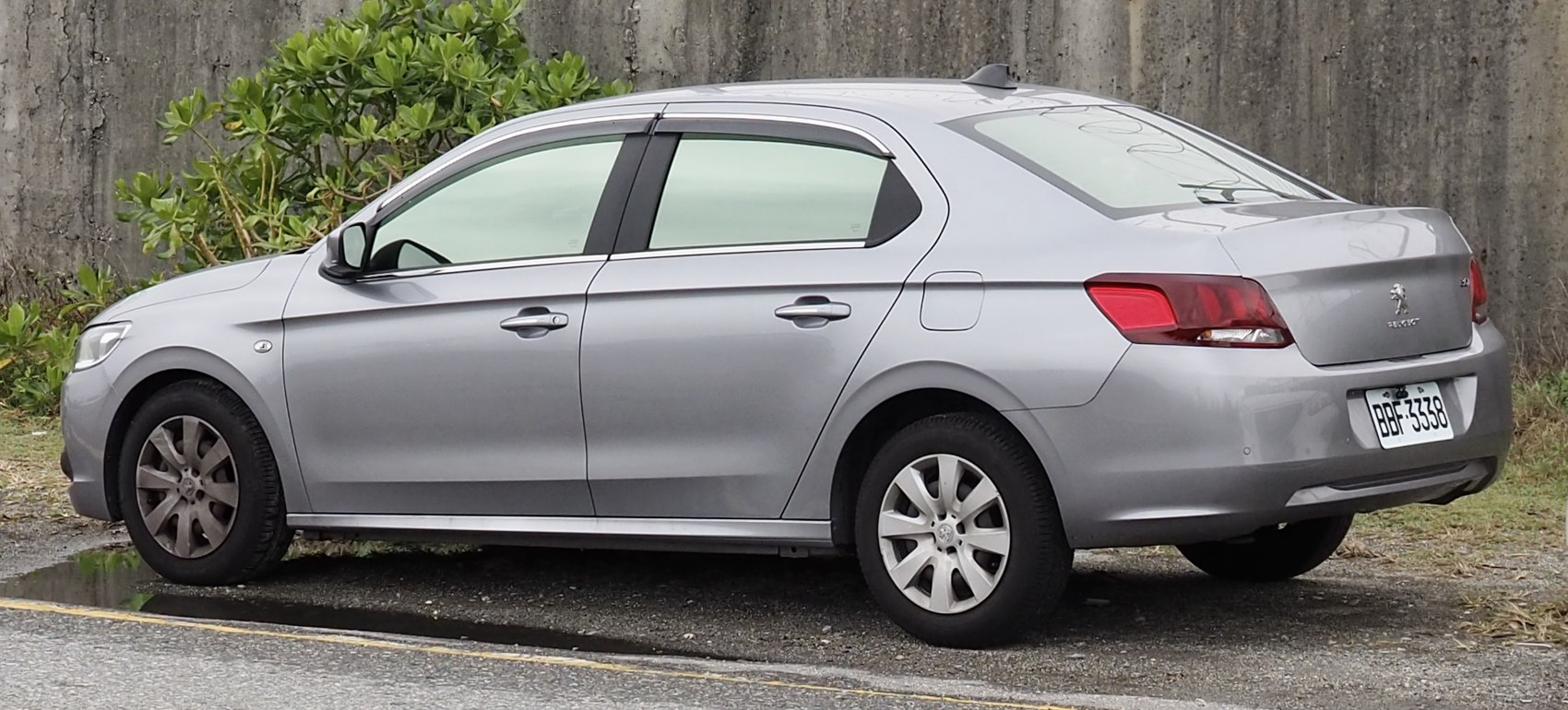 Silver four-door sedan showing rear and side design, taillights, and wheels
