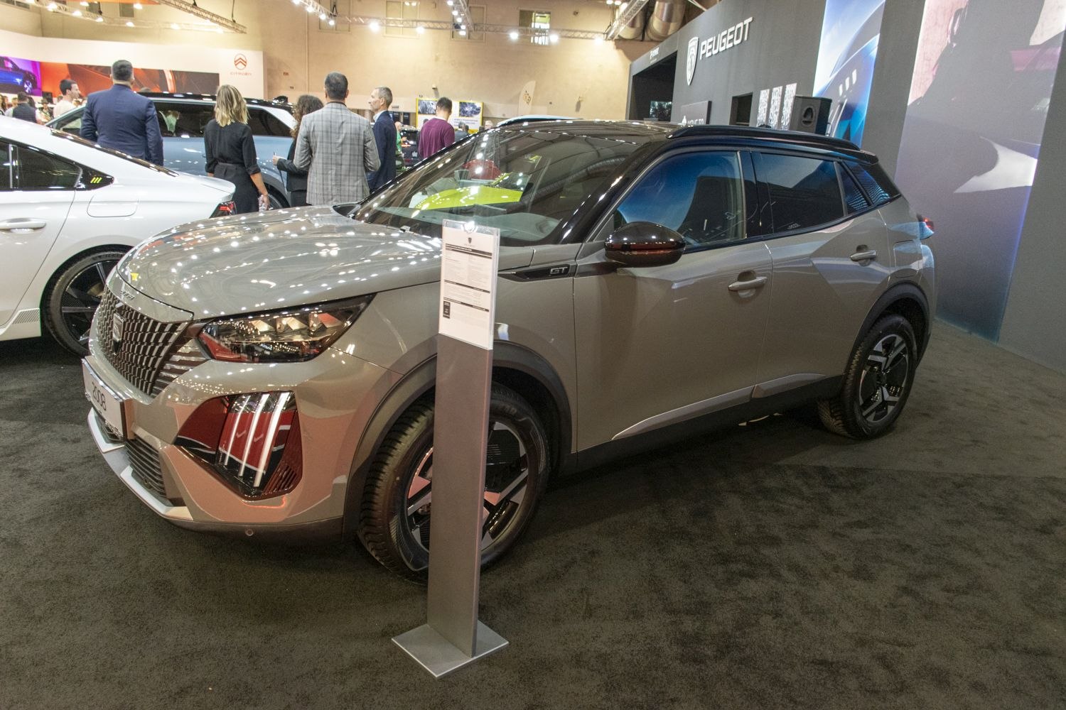 Distinctive front grille and sleek side profile of an SUV showcased indoors