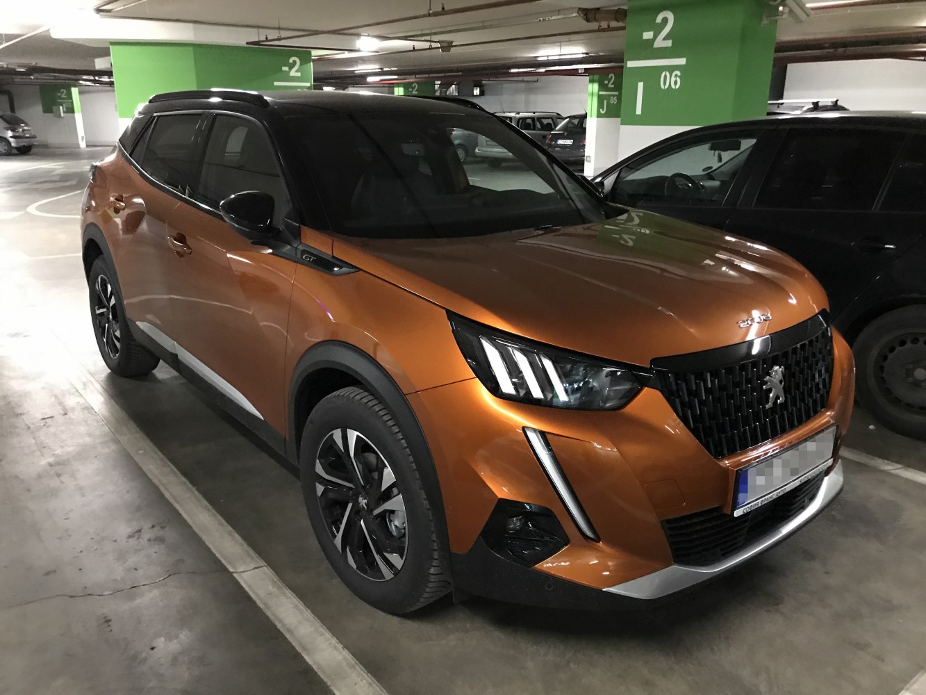 Front view LED headlights and grille of SUV in orange paint