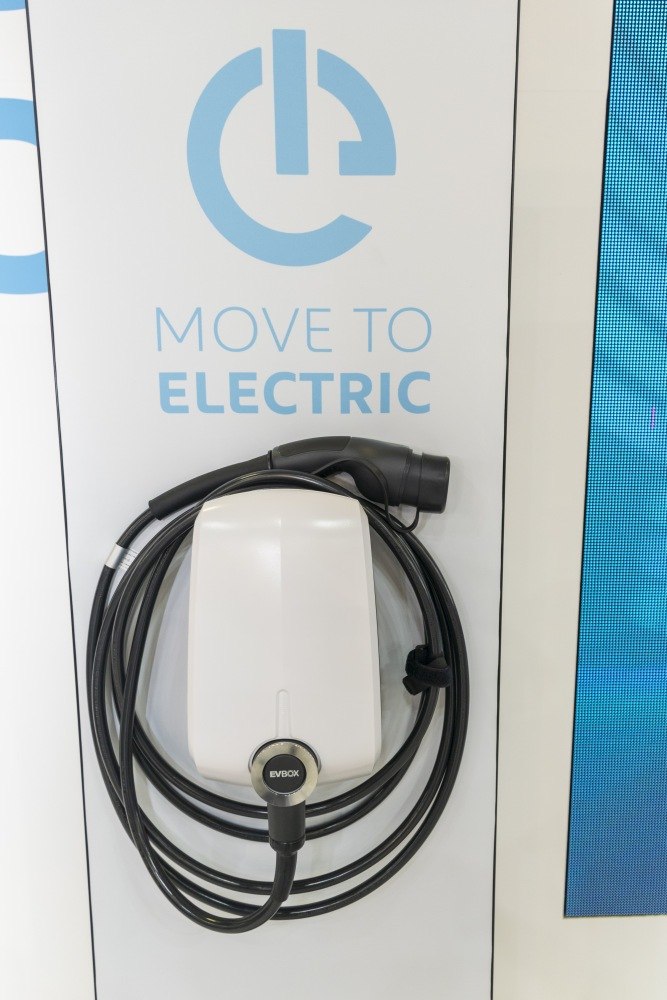 EV charging station device with coiled cable and EVBox plug