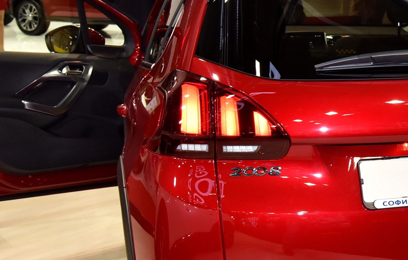 Close-up of rear tail light and model badge on red hatchback