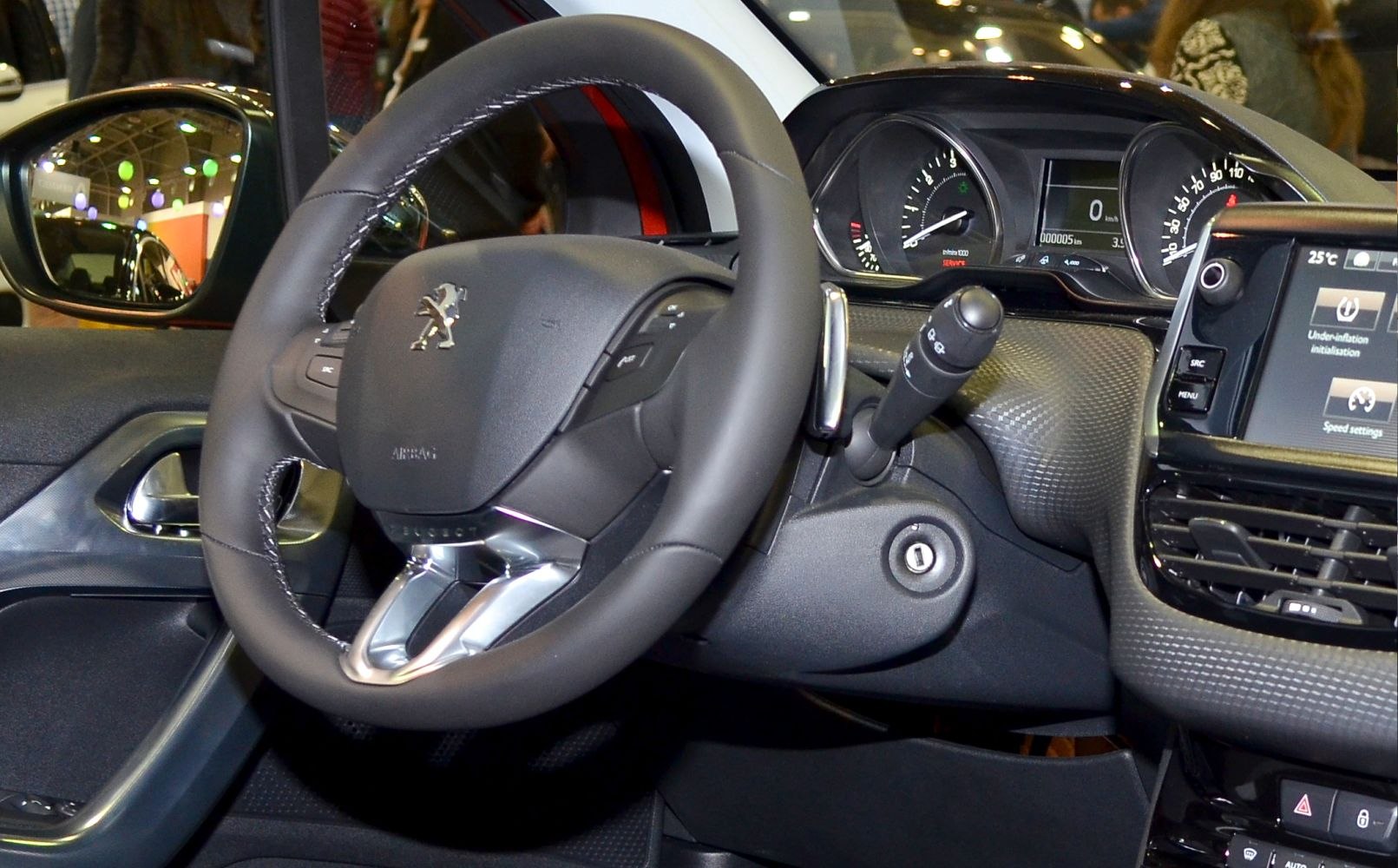 Steering wheel and dashboard with instrument cluster and infotainment system.