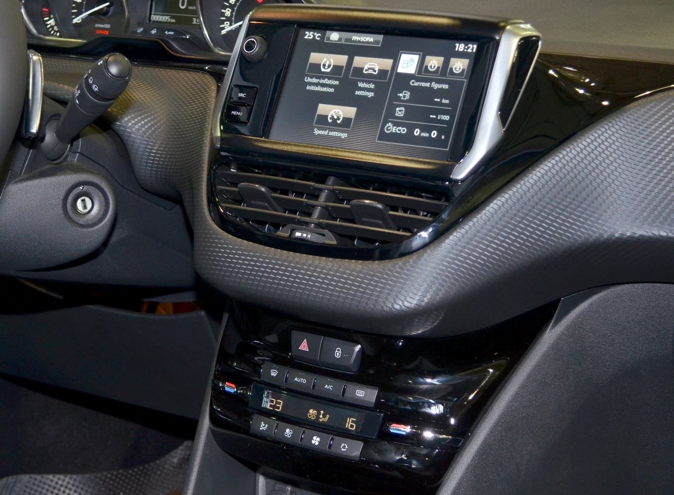 Touchscreen dashboard and climate control panel with textured trim.