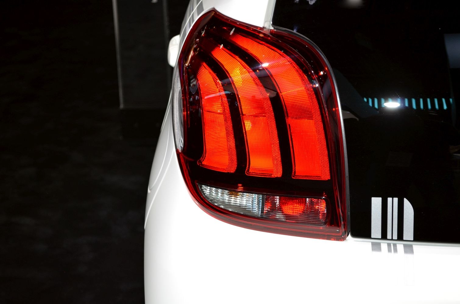 Close-up of a rear taillight with three distinct vertical light bars