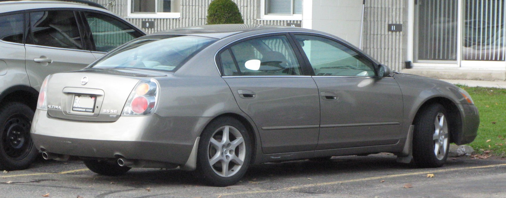 Rear side profile of a sedan with dual exhaust and alloy wheels