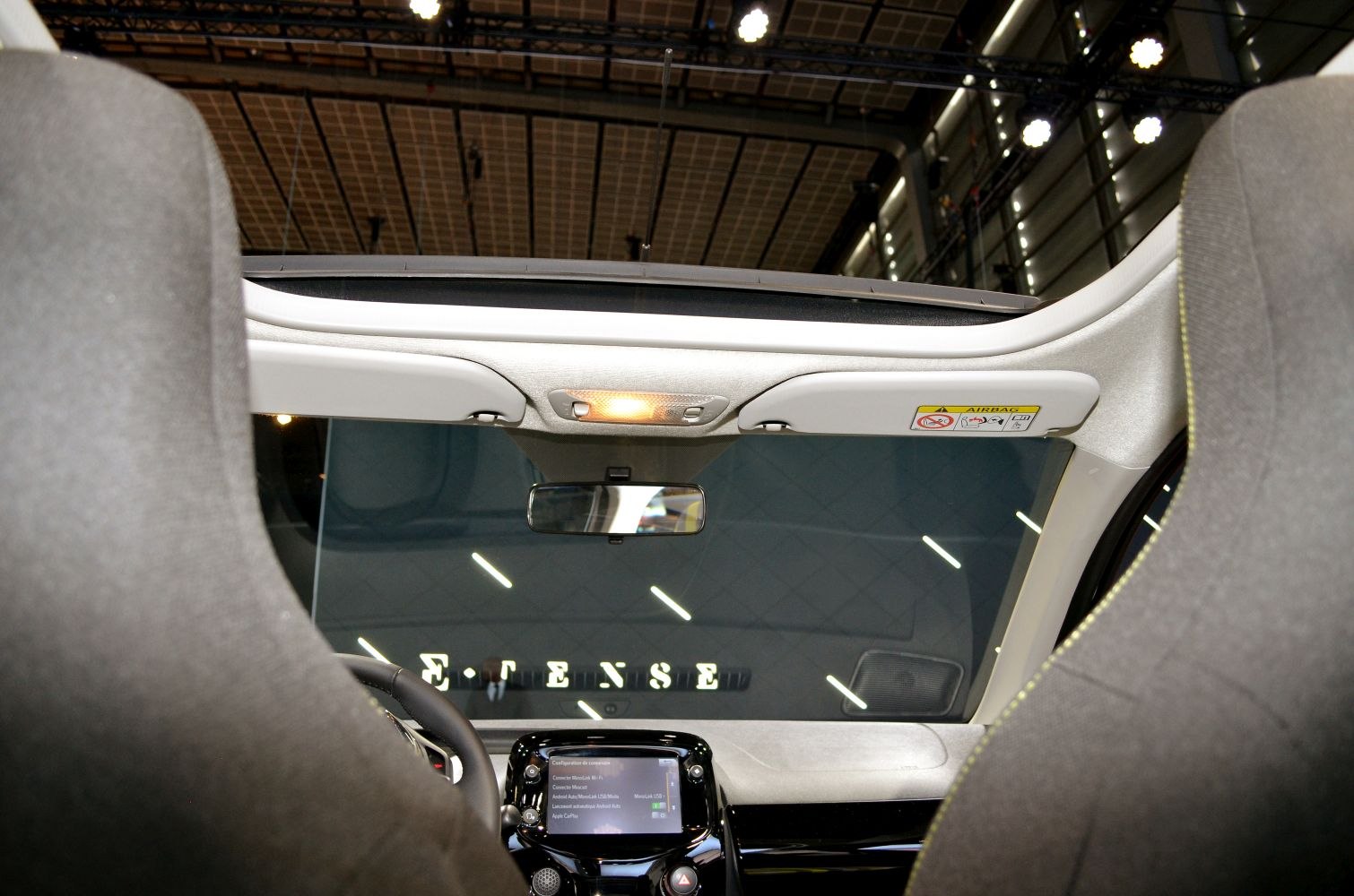 Interior with open roof, rearview mirror, and dashboard infotainment system