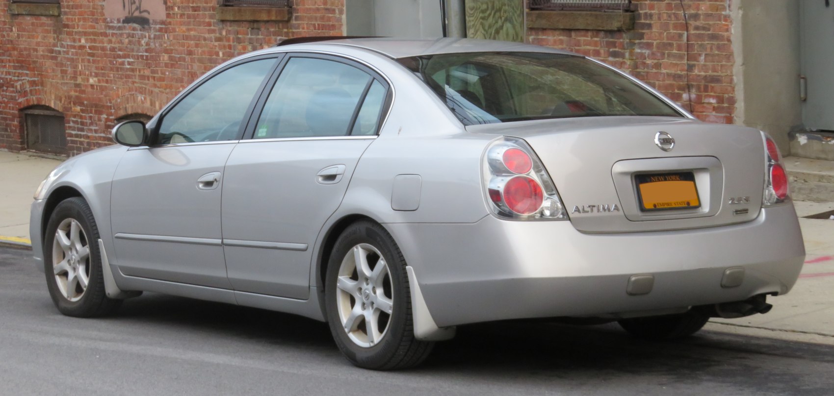 Rear four-door sedan with prominent taillights and alloy wheels.