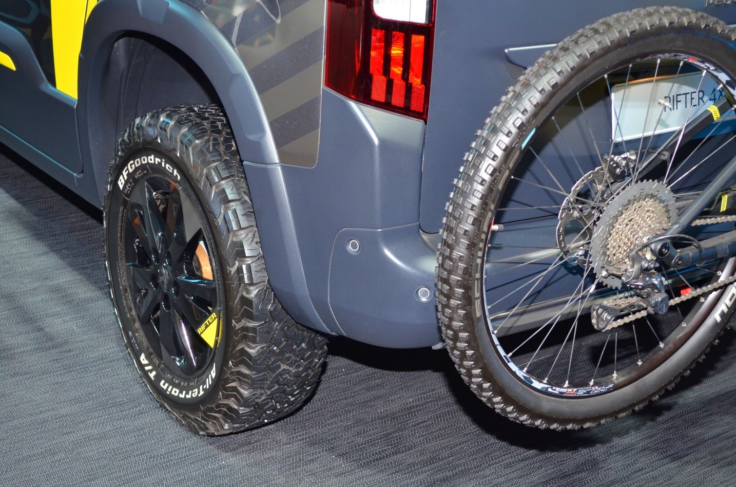 Off-road rear tire and mounted mountain bike wheel on vehicle rear.