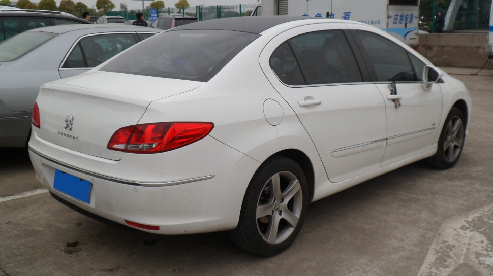 Rear and side view of a white sedan with alloy wheels