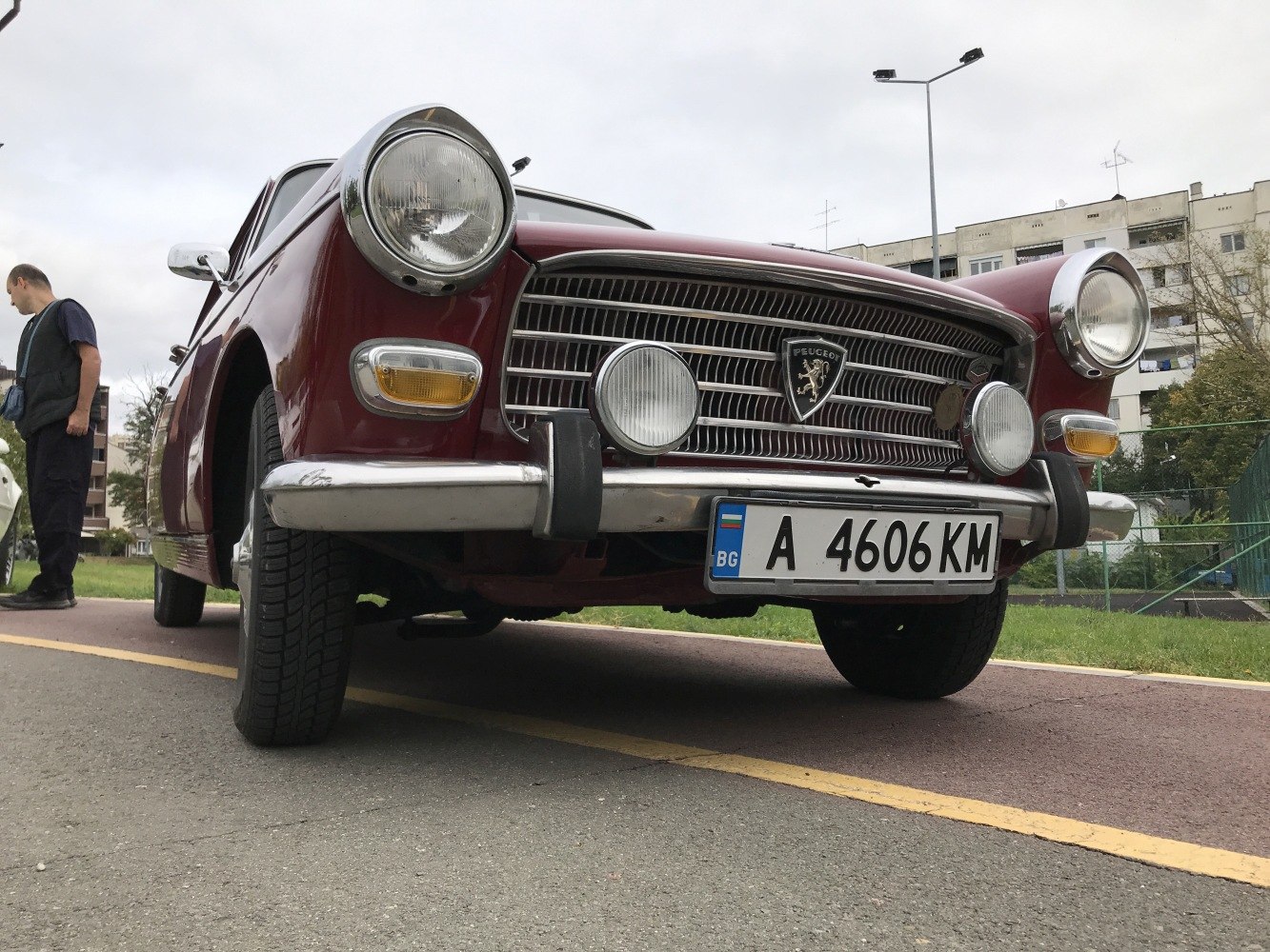 Close-up of vintage car's front grille, round headlights, and fog lights.