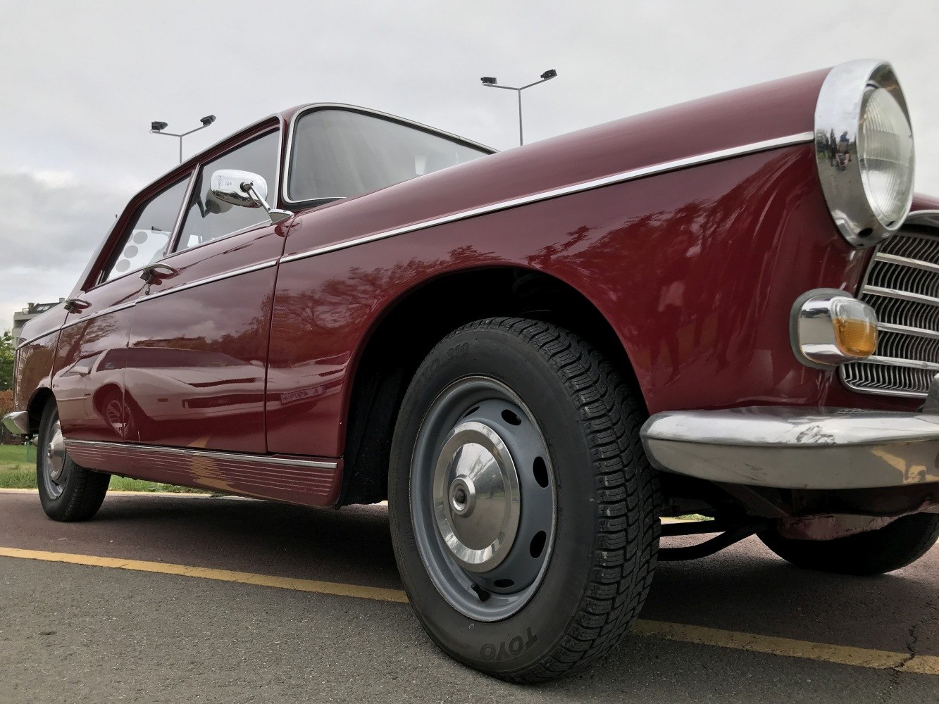 Front and side view of vintage sedan with steel wheels and chrome trim.