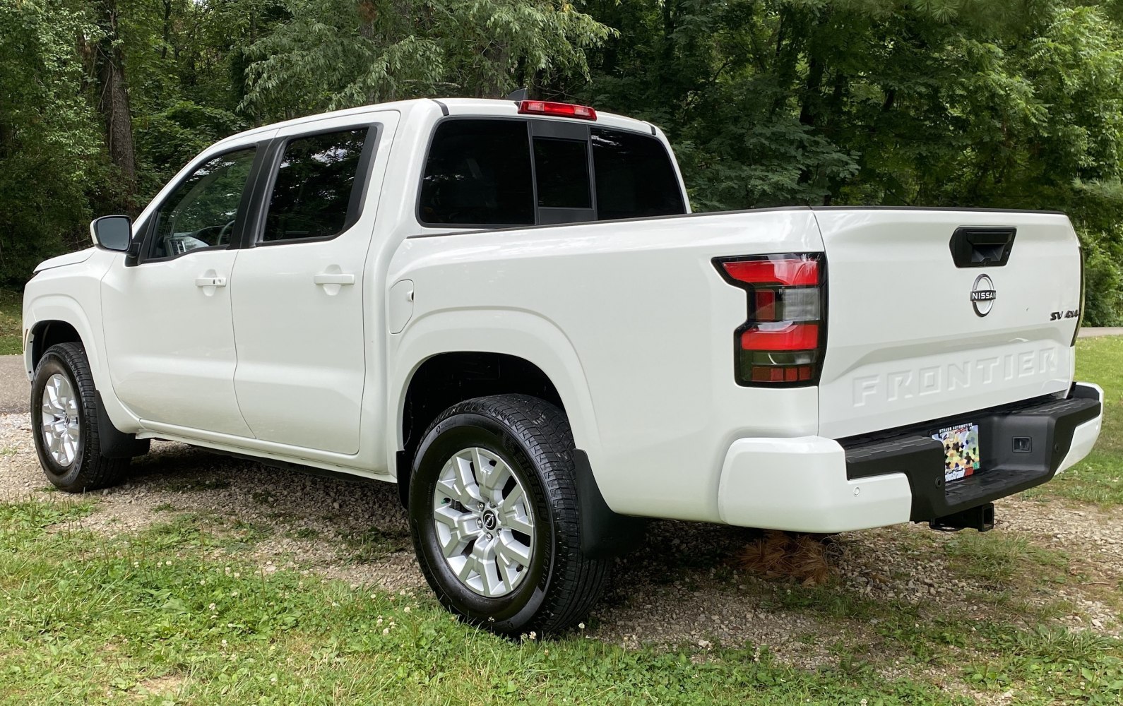 Rear-side view of a crew cab pickup truck with distinctive tailgate and lights