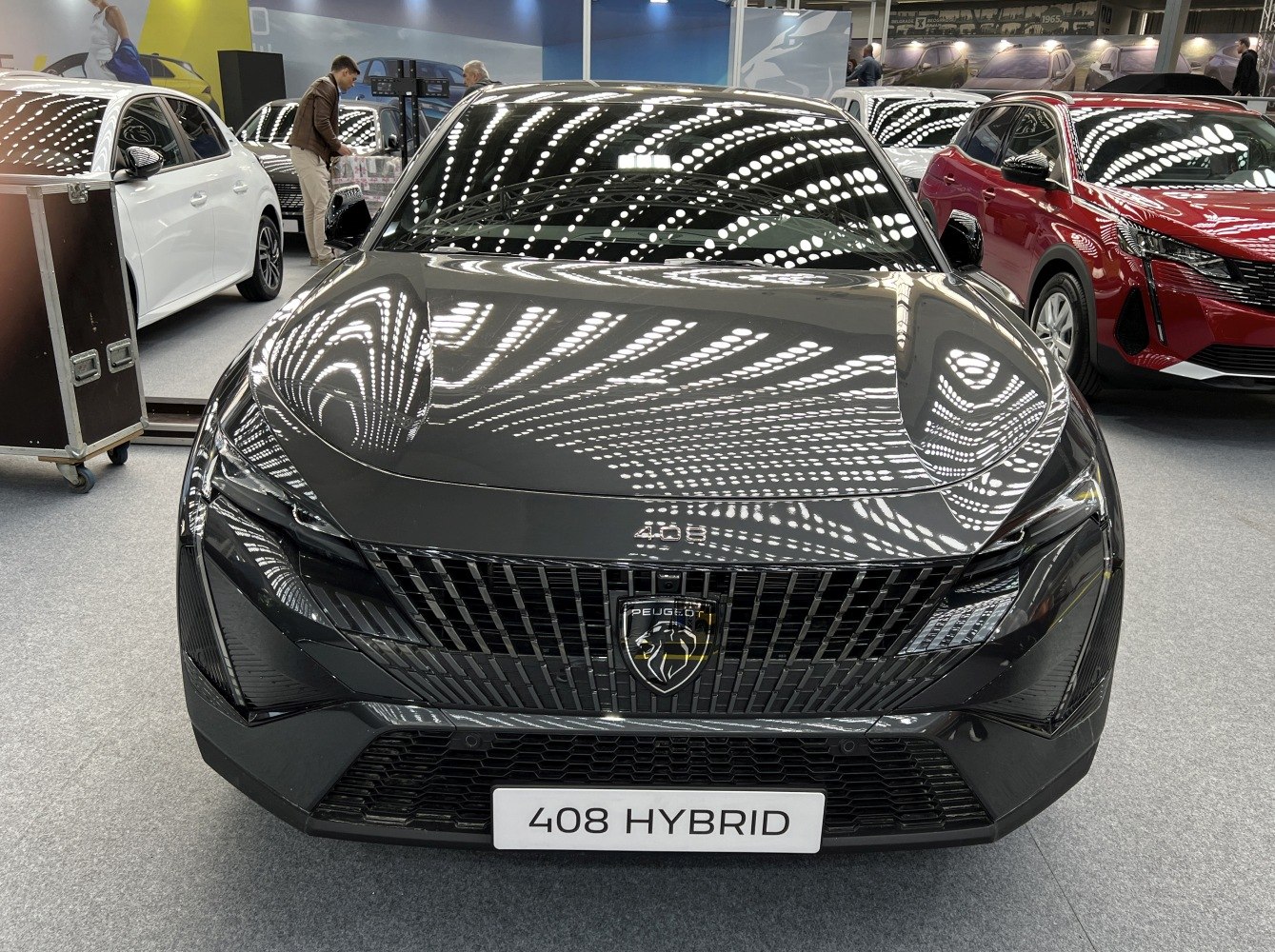 Front view of sleek grille and sharp LED headlights under bright showroom lighting