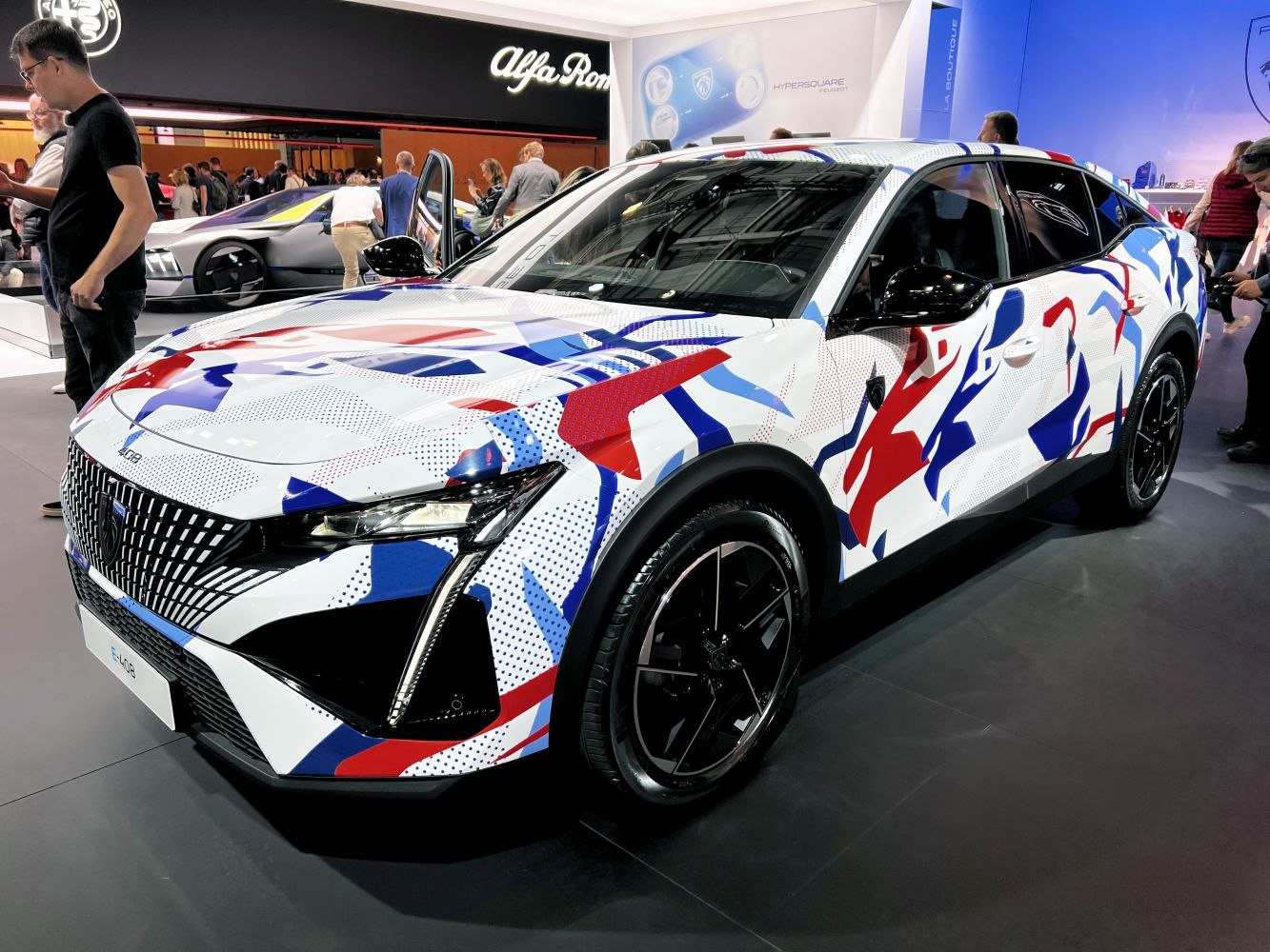 Sleek crossover with geometric camouflage and futuristic front lighting.