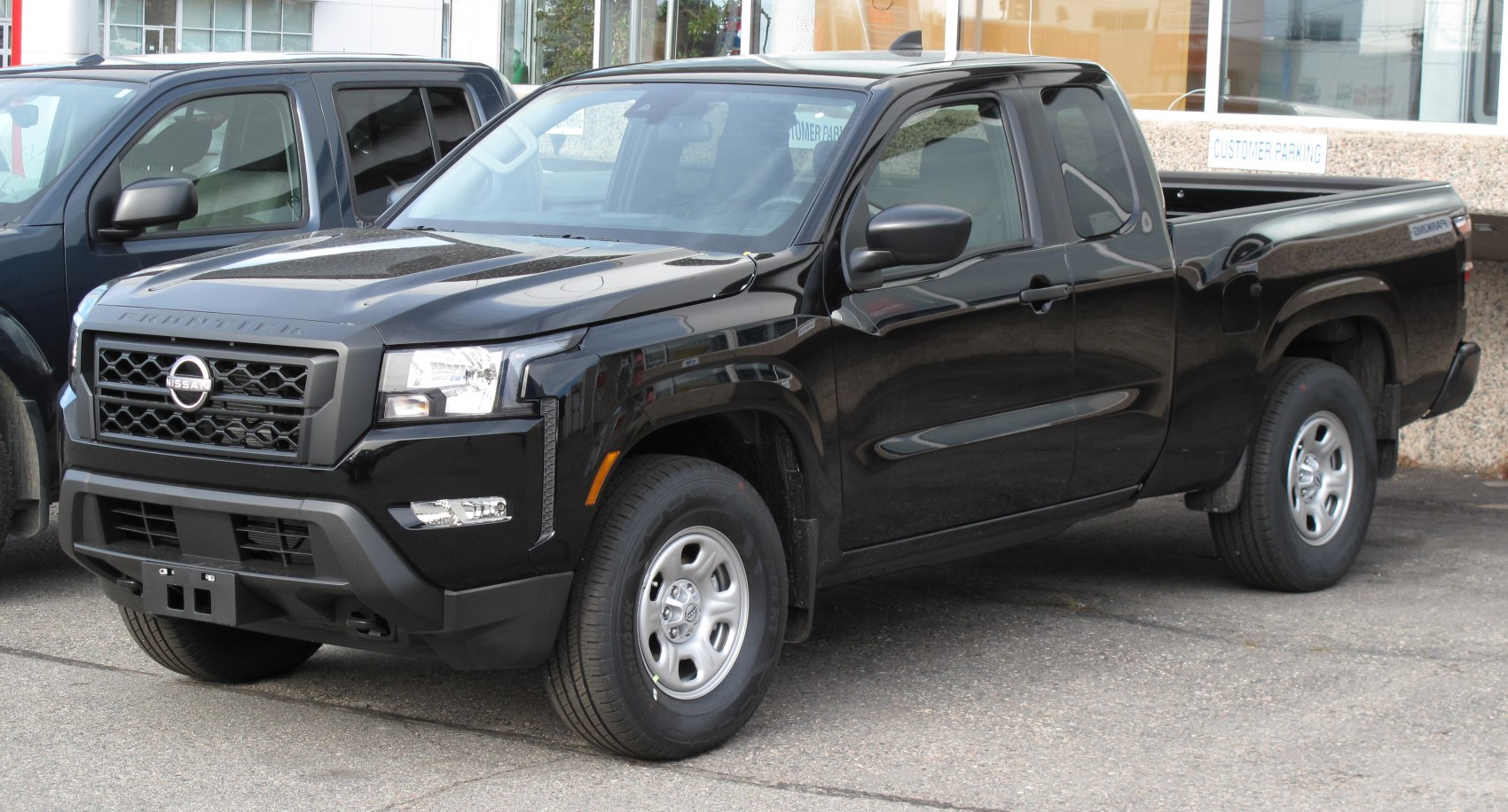 Black extended cab pickup truck with front grille and side mirrors