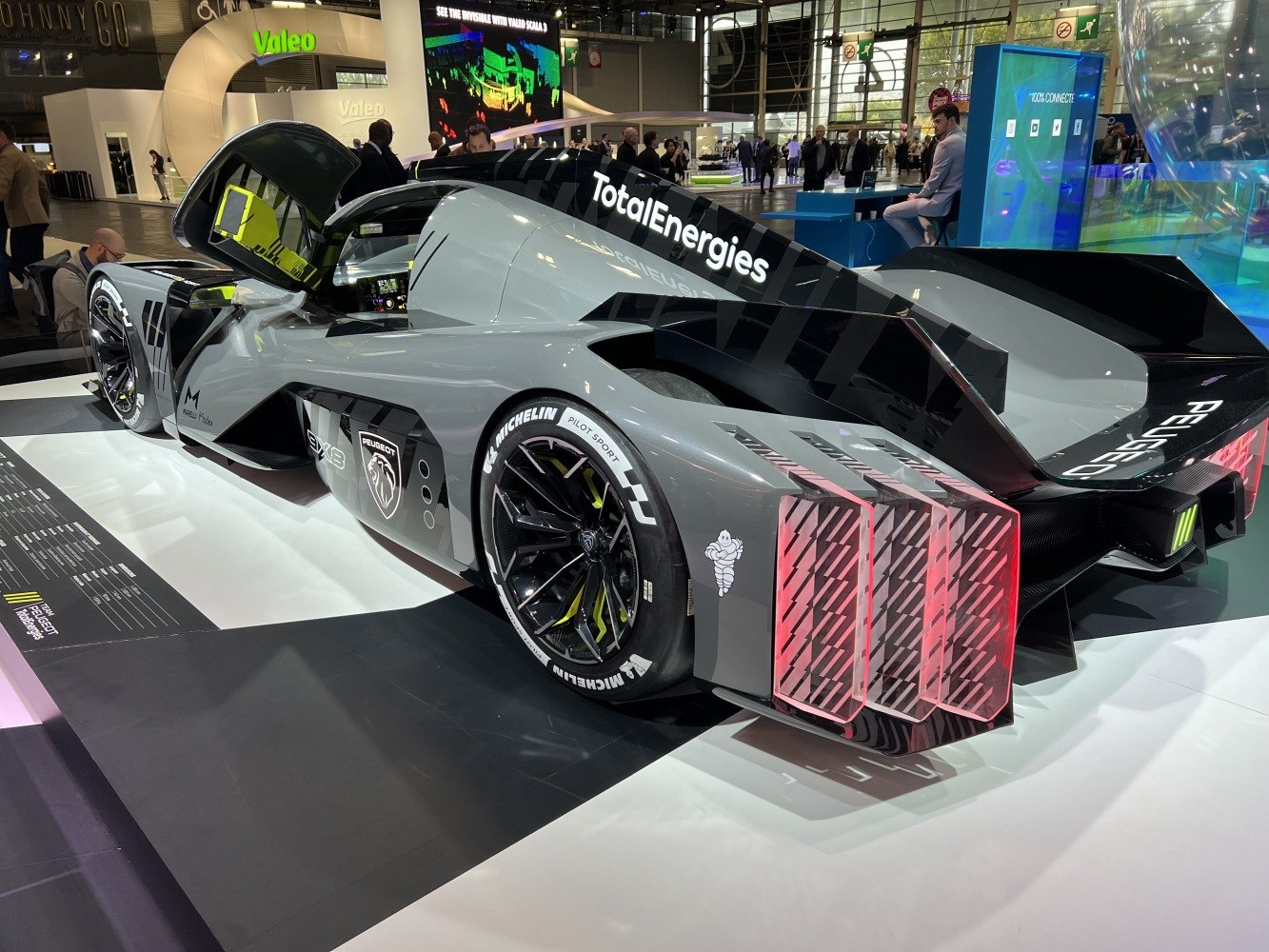 Rear and side view of a racing prototype with open door and distinctive rear lights