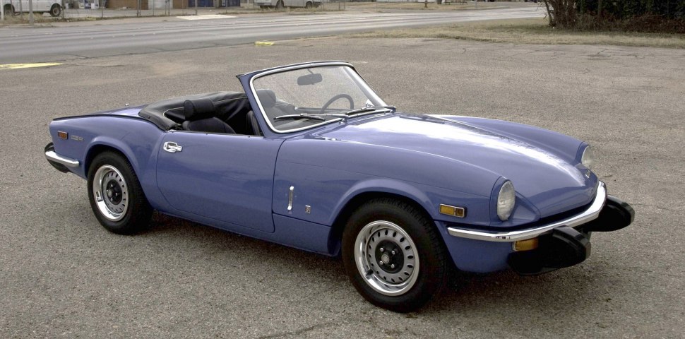 Classic blue convertible with round headlights and chrome bumpers