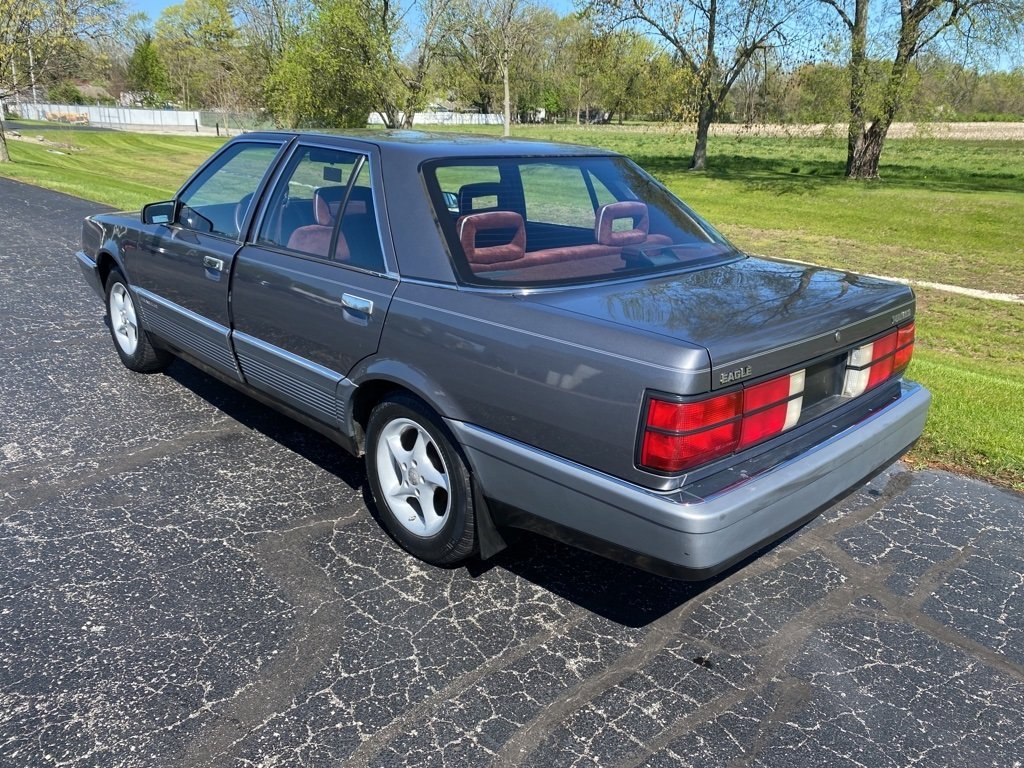 Boxy gray 1980s sedan rear and side view with distinctive taillights