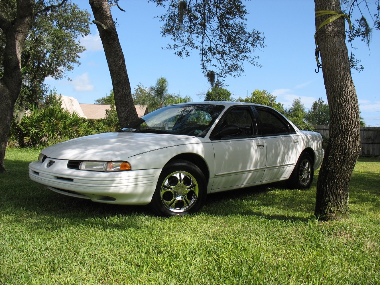 Four-door sedan with sleek body and shiny chrome wheels