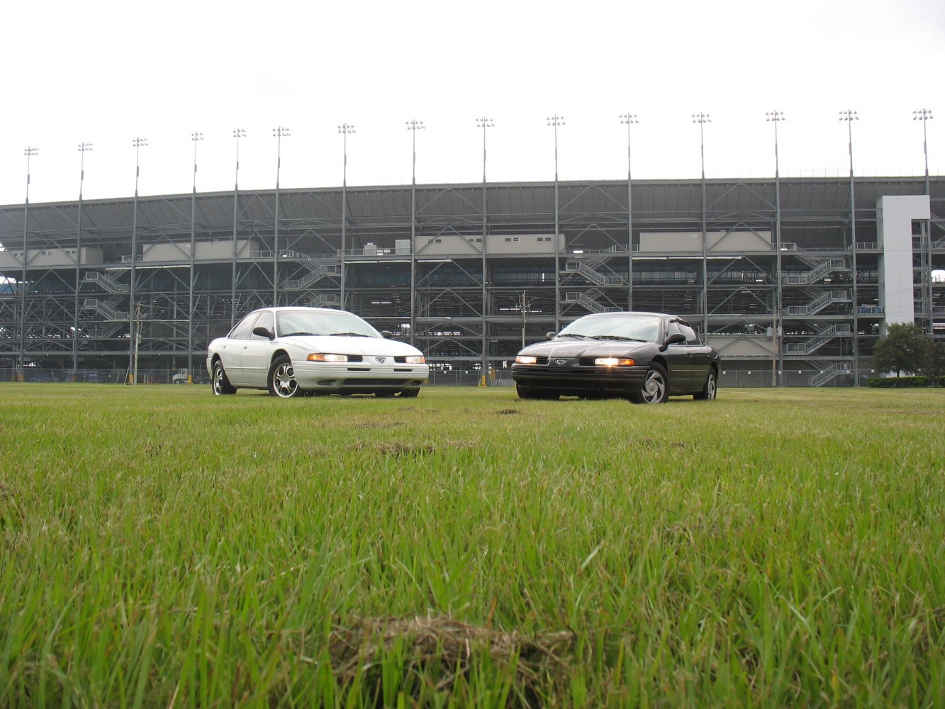 Front view of two early 90s sedans with aerodynamic styling