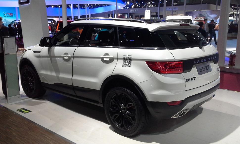 White SUV with black roof, rear side view, black wheels