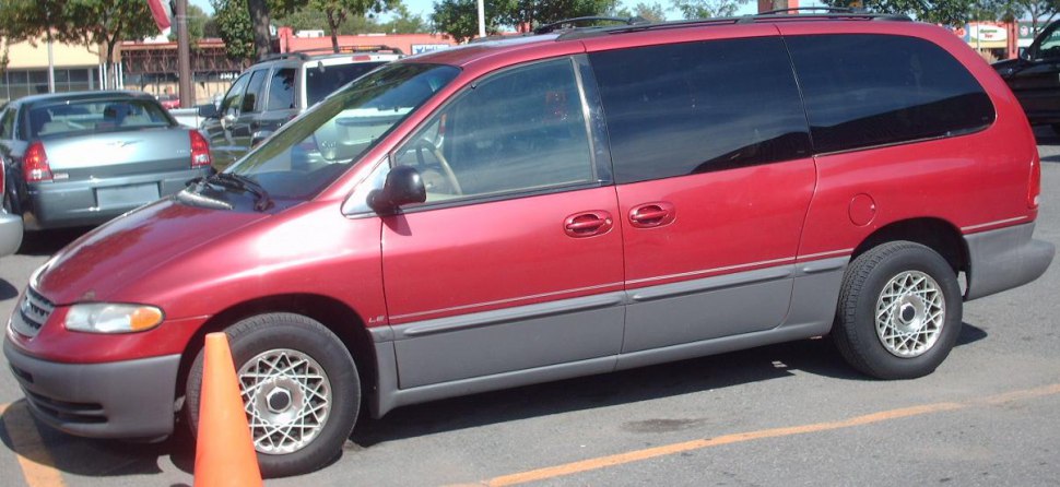 Side view of red minivan with sliding doors and alloy wheels