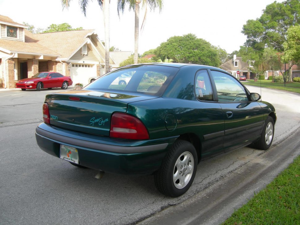 Rear and side view of a dark green compact coupe
