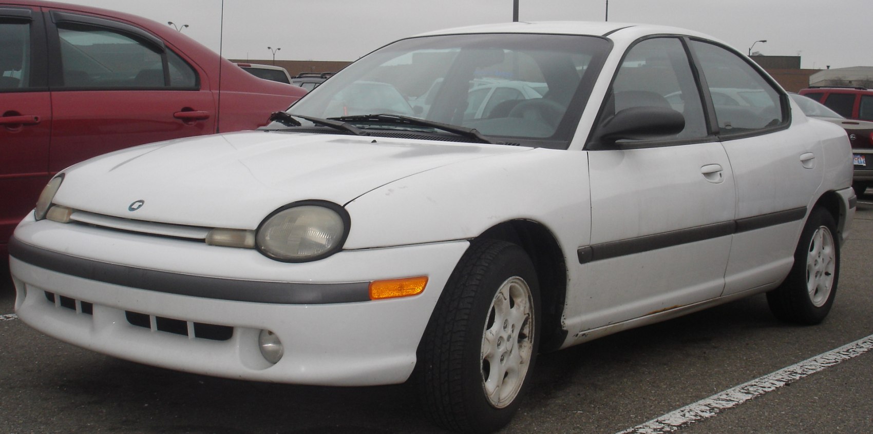 White sedan with rounded headlights and black trim, front and side perspective