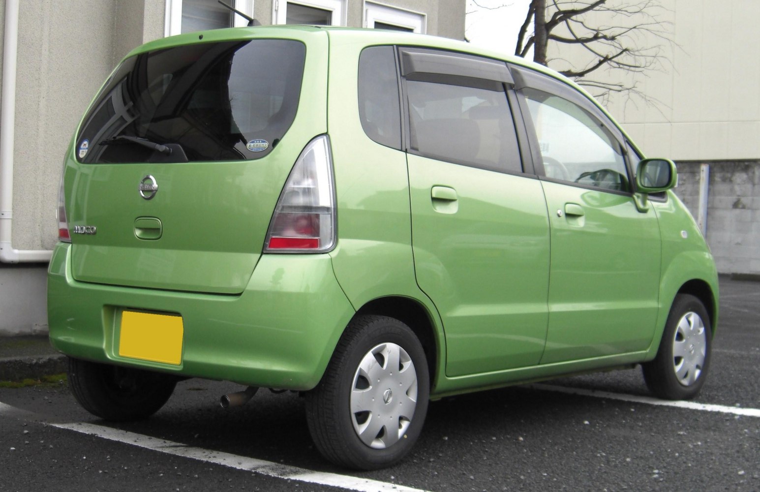 Compact green hatchback with tall rear window and simple wheel covers