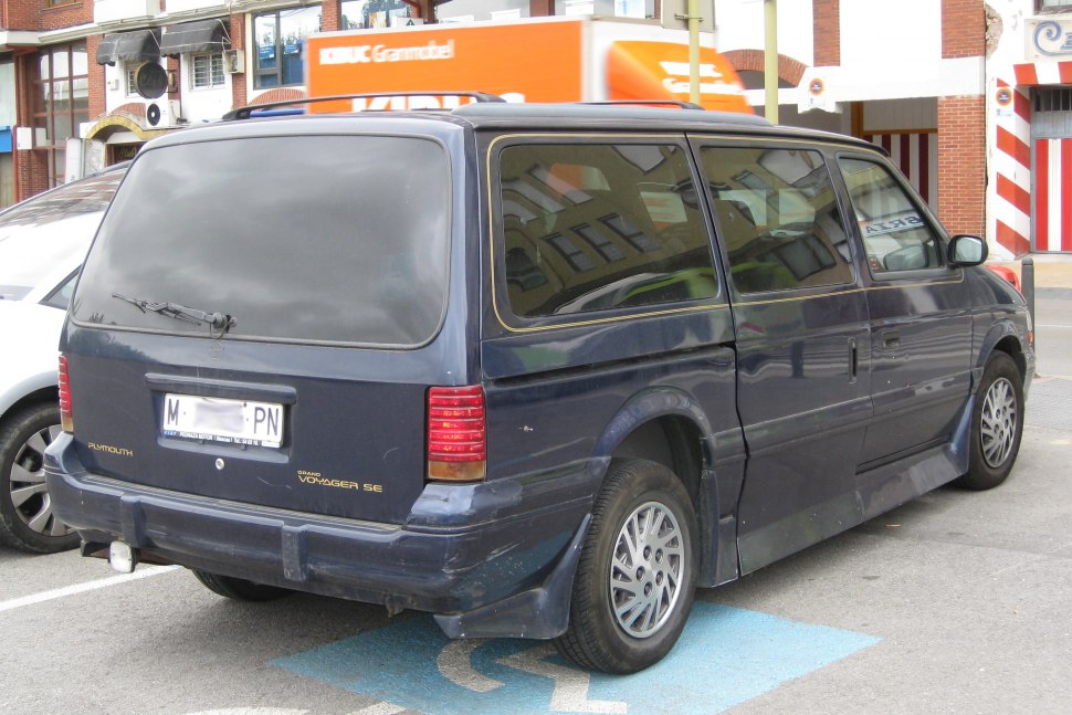 Rear view of a vintage minivan with tinted windows and distinct rear lights