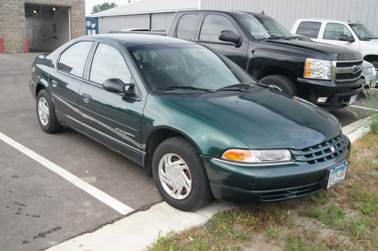 Front side view of a green sedan with grille and wheels