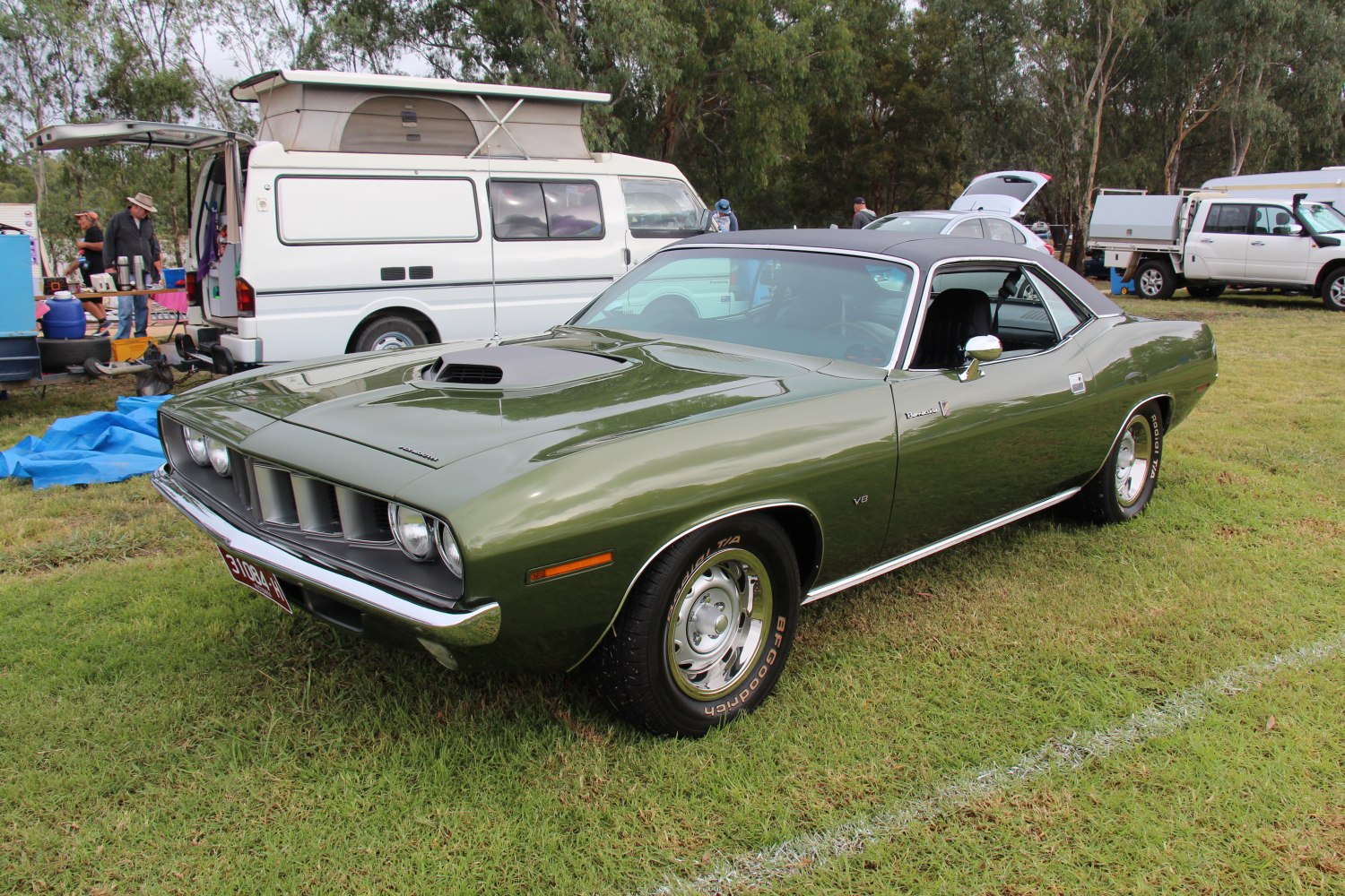 Muscle car with V8 engine, hood scoop, and black vinyl roof.