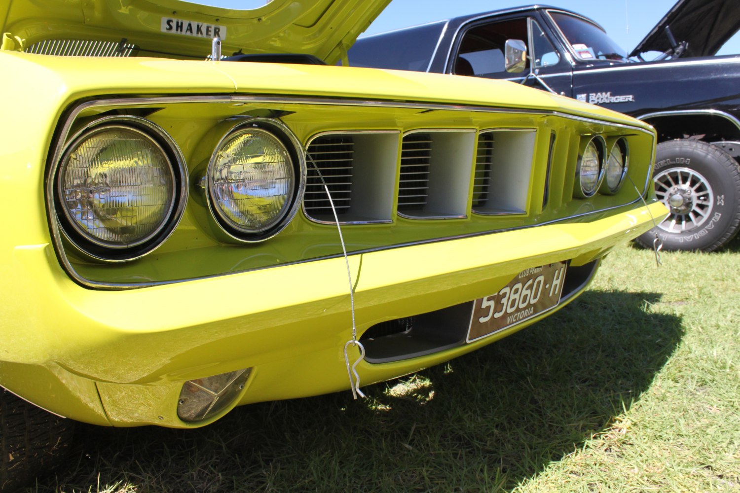 Front grille and quad round headlights of a classic muscle car.