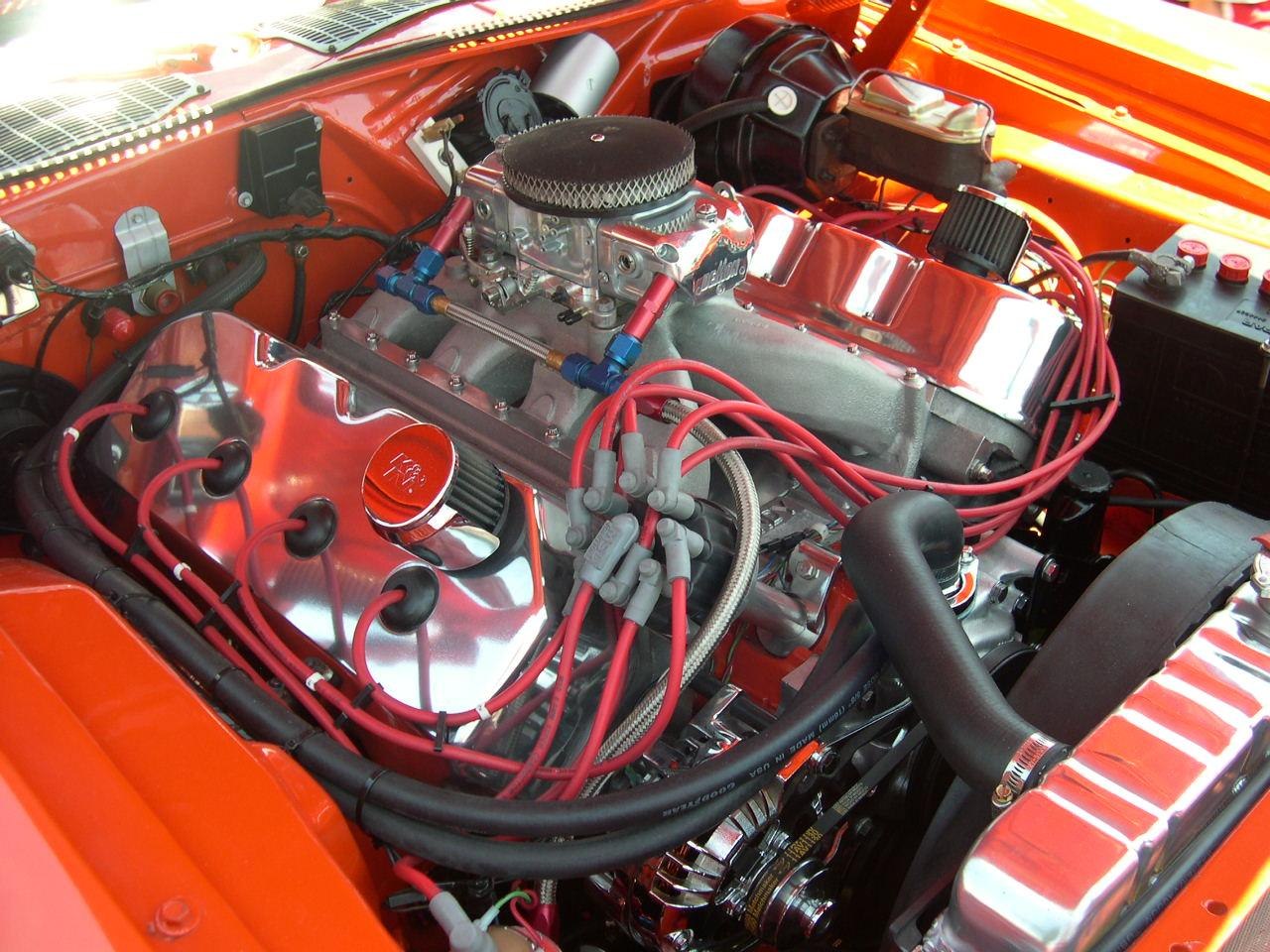 Close-up of muscular engine with chrome valve covers and red ignition wires