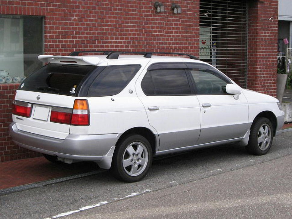Rear side view of a white and silver station wagon with rear spoiler.