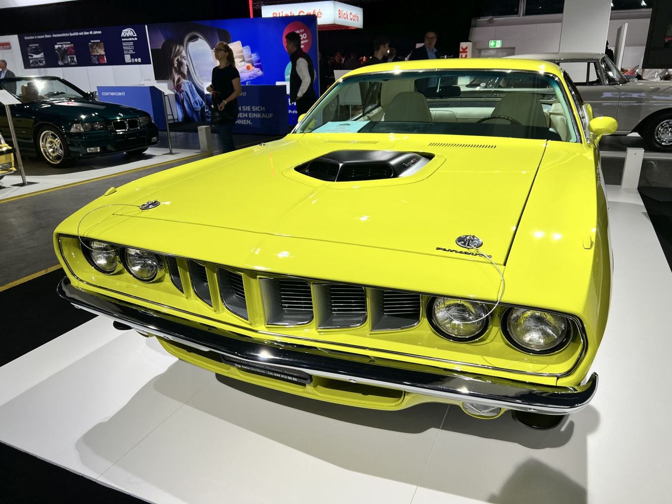 Bright yellow muscle car hood scoop and front grille close-up