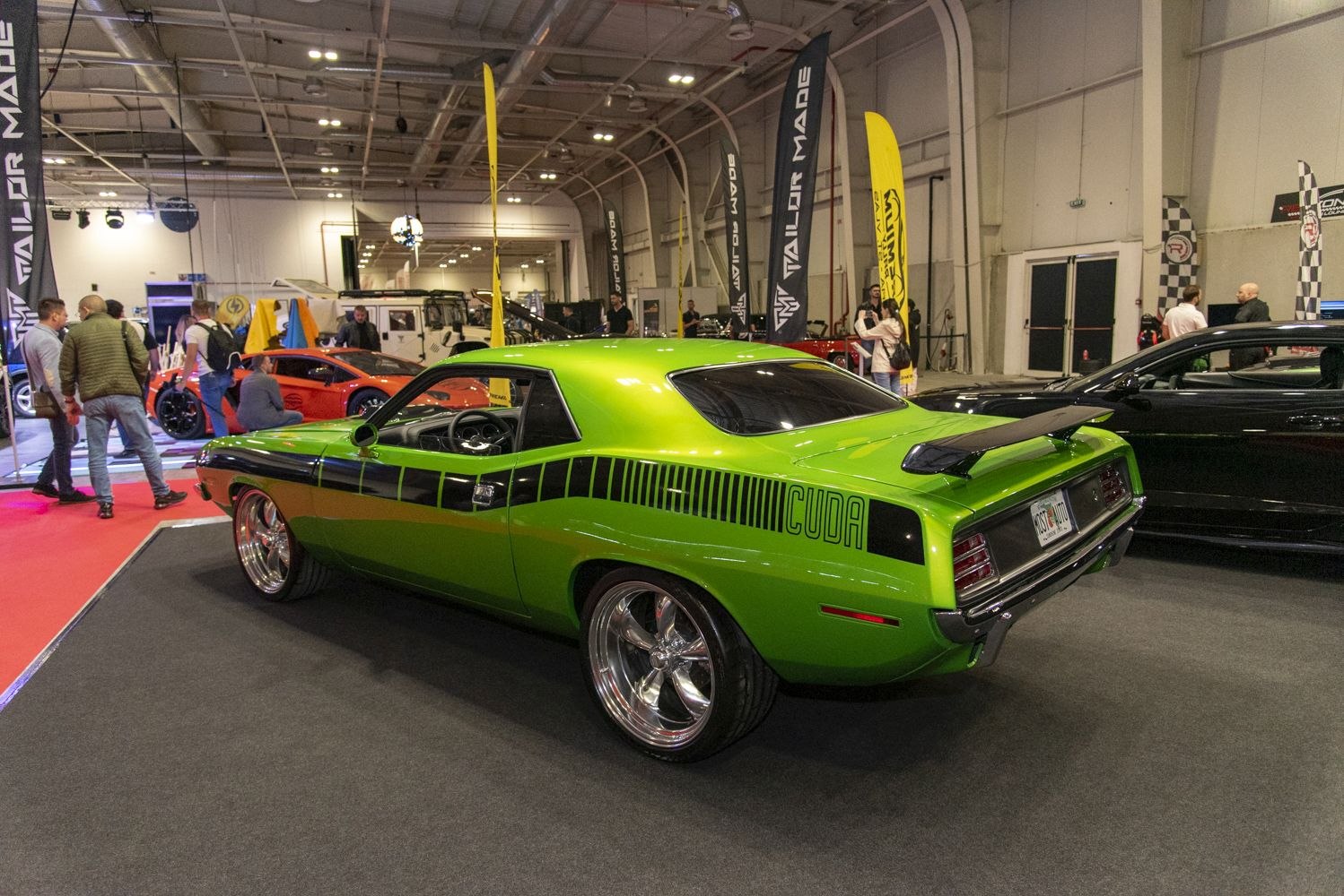 Glossy green muscle car with black stripes and rear spoiler