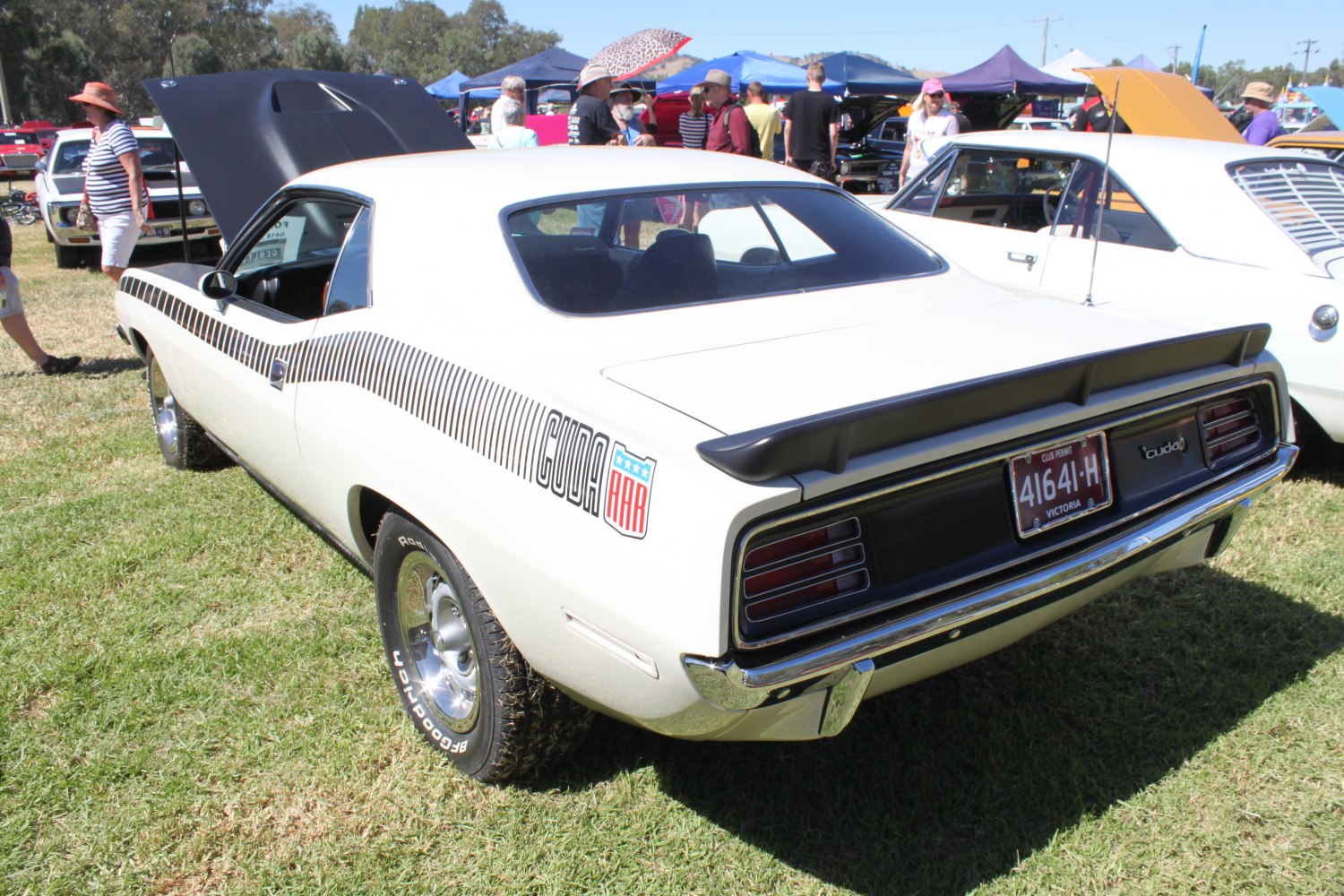 White muscle coupe with black rear spoiler and side stripes