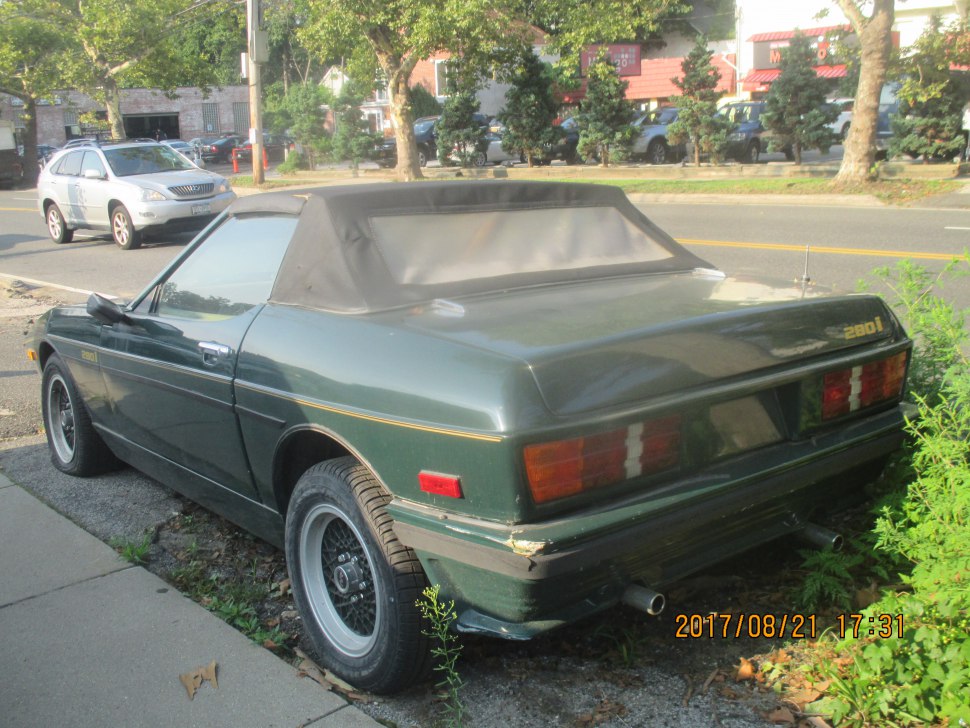 Rear view of vintage convertible with soft top and dual exhaust