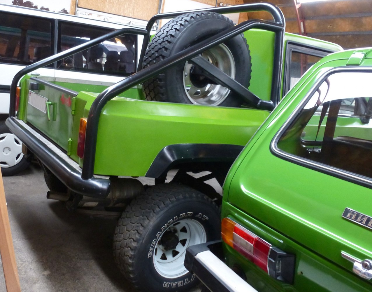Pickup truck bed with spare tire and black roll cage