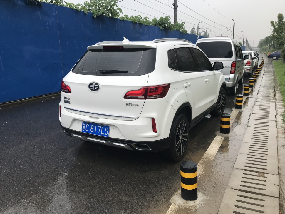 Rear view of white compact SUV with distinct taillights and roof spoiler.