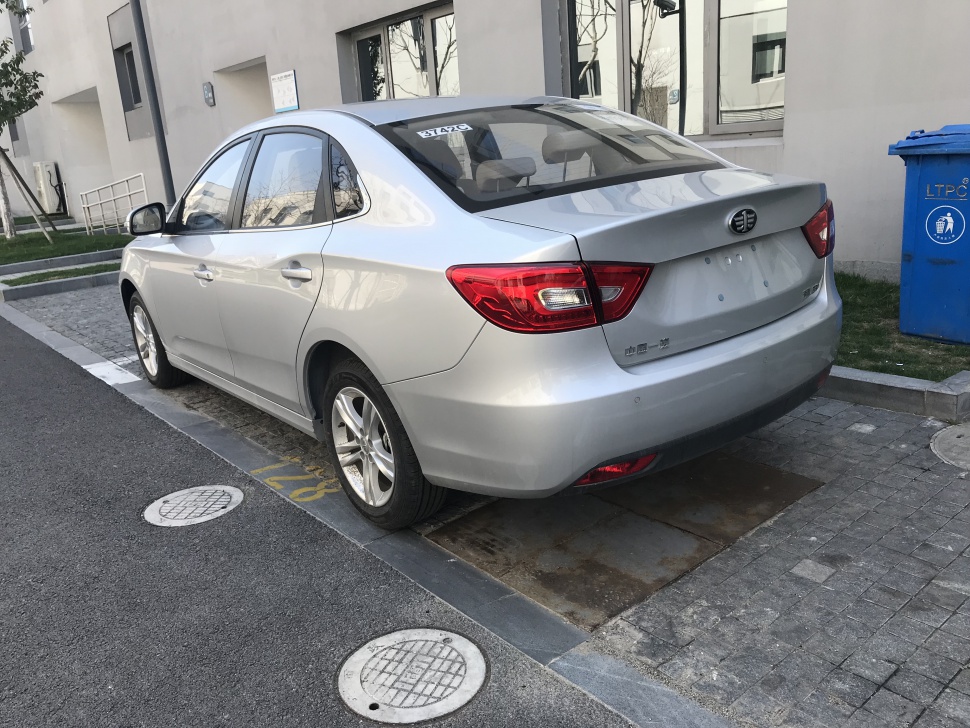 Rear side view of silver four-door sedan with distinct tail lights and alloy wheels