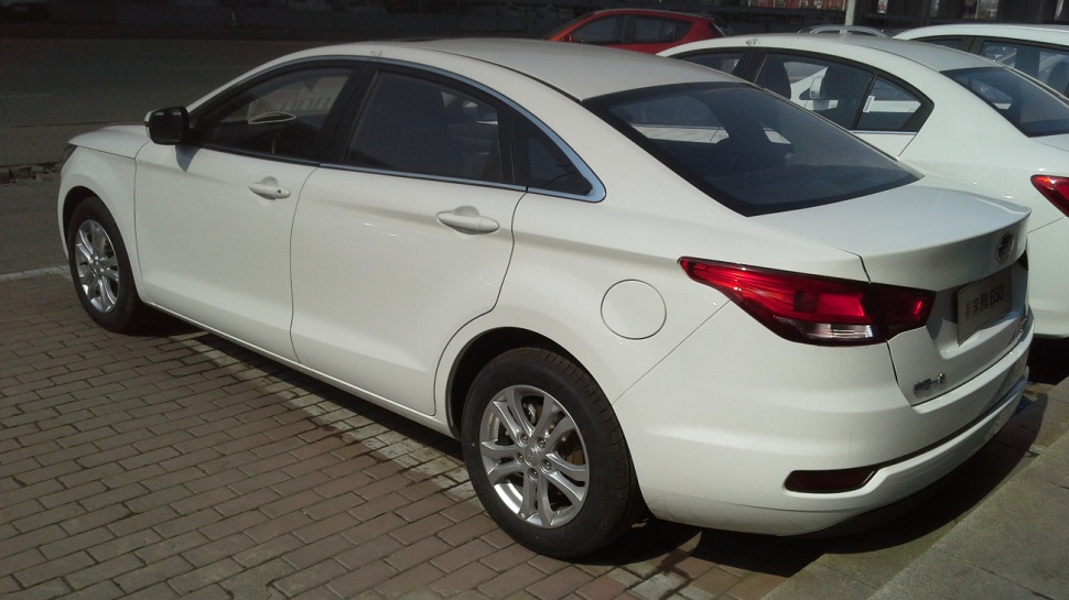 White sedan rear and side view with alloy wheels and taillights
