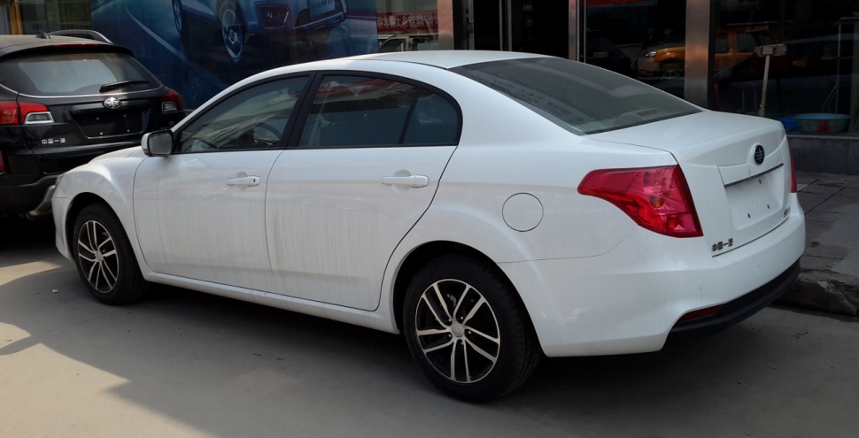 Rear side profile of white compact sedan with alloy wheels